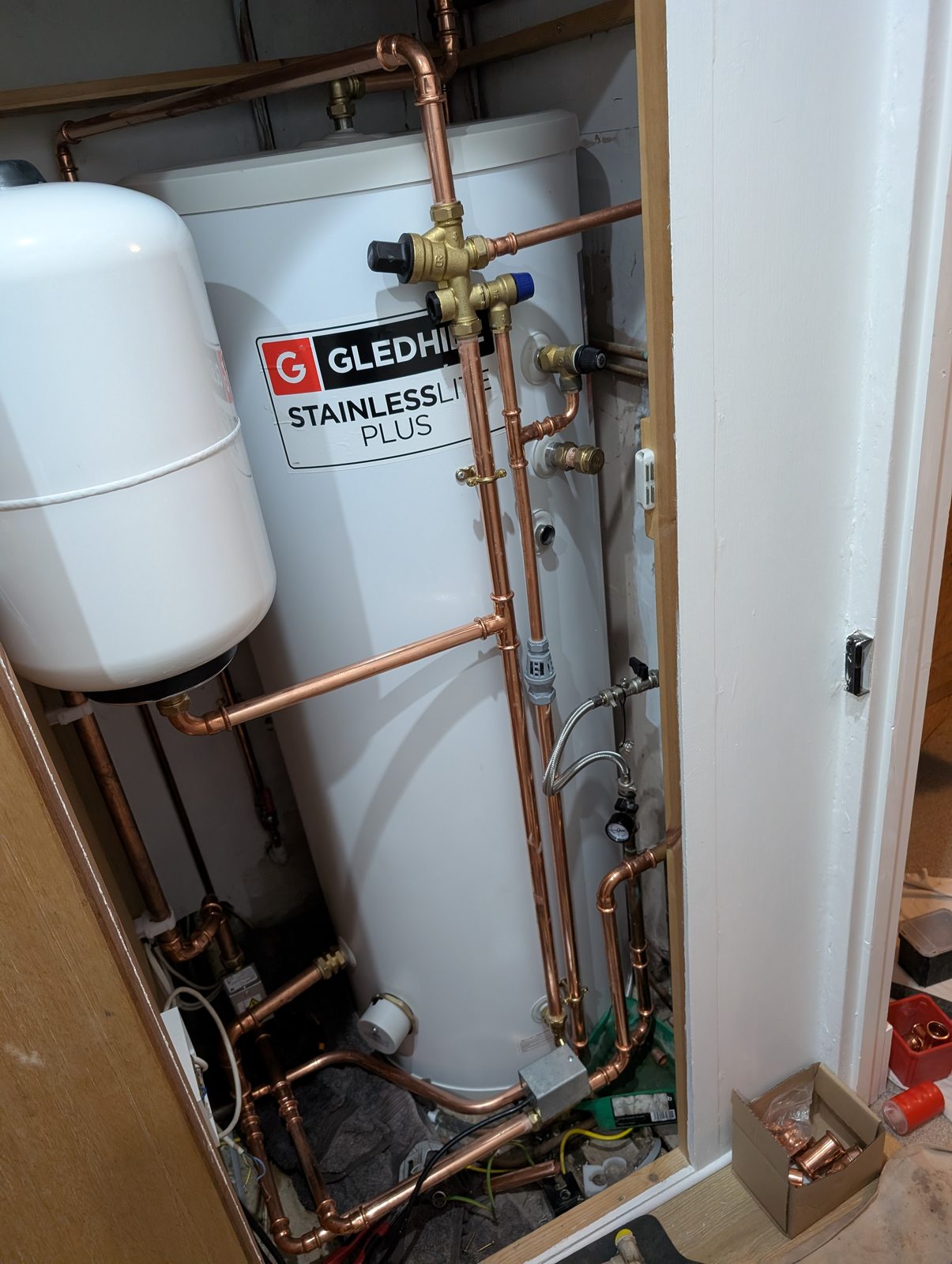 J6 unvented hot water cylinder and copper pipework in an airing cupboard